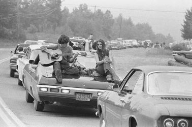 On the Road to Woodstock
A couple play the guitar sitting on their car on the way to the Woodstock Festival, August 1969.